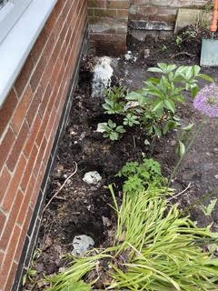 Ground stabilisation work beside a brick wall